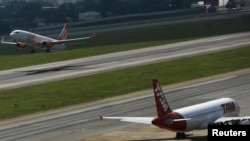Brazilian airline GOL's Boeing 737-800 aircraft, left, takes off near TAM's Airbus A320 aircraft at Congonhas airport, Sao Paulo, Jan. 17, 2014.