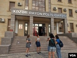 Azerbaijani women's rights activists threw red paint on the door of the local police station in protest to the authorities' inaction in response to complaints about domestic violence, Baku, Azerbaijan, Aug. 4, 2021. (Ulviyya Guliyeva/VOA)