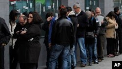People wait outside an unemployment office in Madrid, Spain, Apr. 2, 2013. 