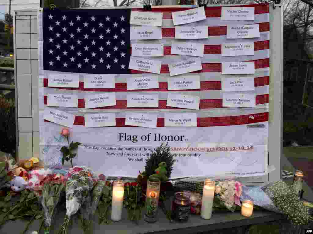 Names of victims are displayed on a flag in the business area in Newtown, Connecticut, December 16, 2012.