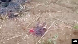 FILE - In this from video taken Dec. 7, 2021, a bloodstain is seen on the ground in Done Taw village in the Sagaing region of Myanmar. Outrage spread on social media over images and accounts of the alleged killing and burning of 11 villagers captured by government troops.