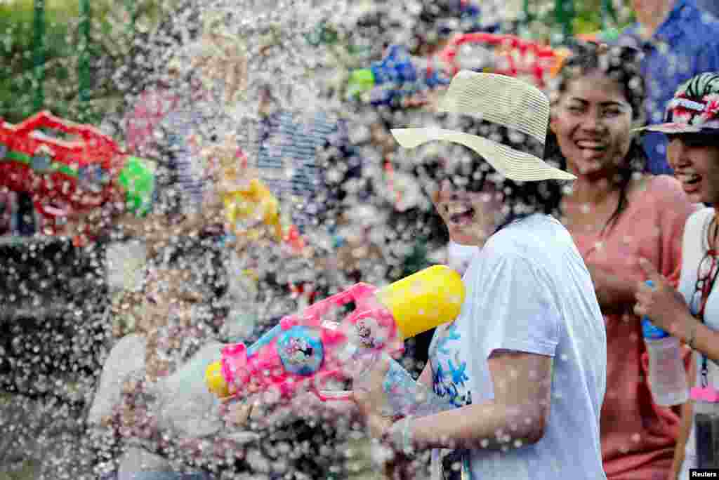 មនុស្សម្នាកំពុងចូលរួមសប្បាយរីករាយបាញ់ទឹកដាក់គ្នាក្នុងបុណ្យមហាសង្ក្រានឆ្នាំថ្មីនៅក្រុងបាងកក ប្រទេសថៃ។