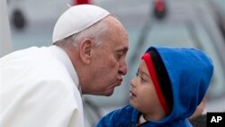 24일 브라질 상파울루의 성지에 도착한 프란치스코 교황이 한 소년의 볼에 입맞추고 있다.