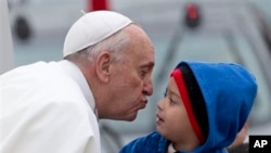 Ðức Giáo Hoàng cúi hôn một em bé trên đường đến Aparecida, Brazil, ngày 24/7/2013.