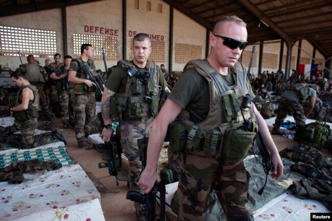 FILE - French soldiers leave a hangar at the Malian army air base in Bamako, Jan. 14, 2013. France had poured hundreds of troops into Bamako at the time, carrying out air raids in a vast desert area seized the year before by an Islamist alliance grouping al-Qaida's north African wing, AQIM, and Mali's homegrown MUJWA and Ansar Dine militant groups.