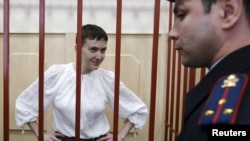 FILE - Ukrainian military pilot Nadezhda Savchenko stands inside a defendants' cage as she attends a court hearing in Moscow, April 17, 2015. 