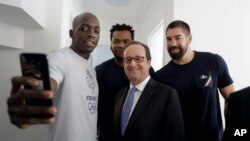 El presidente François Hollande, en la foto con atletas olímpicos de su país, viajó a Río para una serie de encuentros con miembros del Comité Olímpico Internacional.