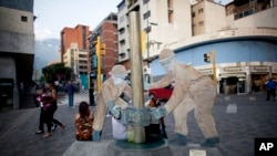 FILE - A sculpture of oil workers — figures who represent an industry critical to Venezuela's economic well-being — decorates a sidewalk in Caracas, Oct. 23, 2014.