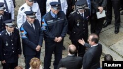 Le président français François Hollande et son ministre de l'Intérieur Bernard Cazeneuve lors de la cérémonie d'hommage au policier Jean-Baptiste Salvaing et sa femme, agent administratif Jessica Schneider, tués à coup de couteau par Larossi Abballa, à Paris, France, le 15 juin 2016.