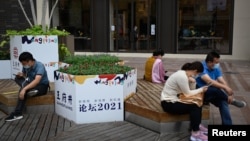 北京的一條商業街上的商店門口站著一名嚮往張望的銷售員。 （2021年9月15日）