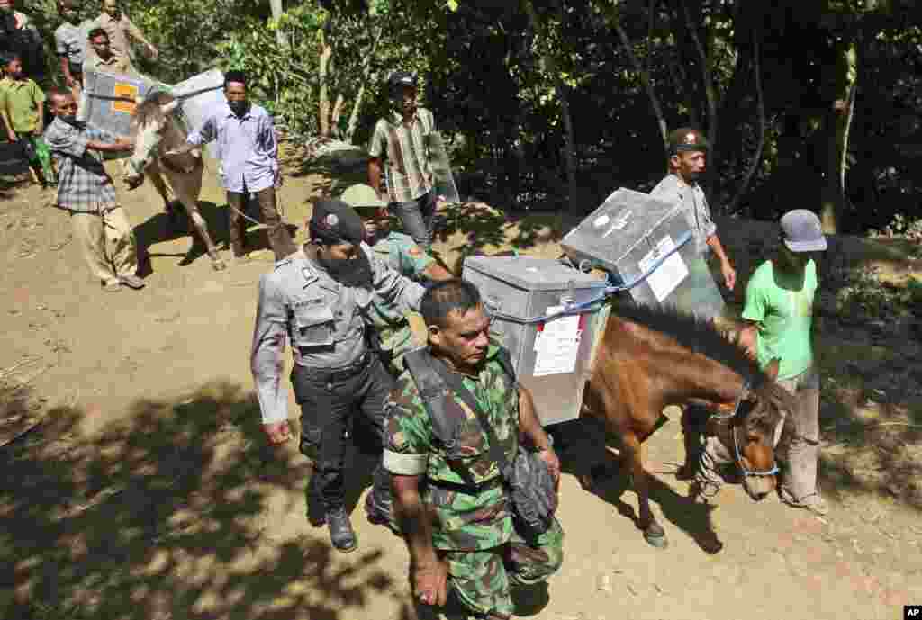 Petugas pemilu, dikawal polisi dan tentara, menggunakan kuda untuk membawa kertas-kertas suara ke TPS-TPS di daerah terpencil di Tlogosari, Jawa Timur (8/7).&nbsp;(AP/Heri Juanda)