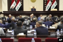 FILE - Iraqi Prime Minister Haider al-Abadi, center, attends a session of the Iraqi Parliament, in Baghdad, Iraq, Sept. 27, 2017.