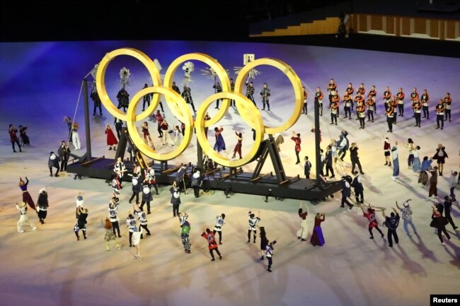 Para penampil membentuk cincin Olimpiade saat upacara pembukaan. (REUTERS/Fabrizio Bensch)
