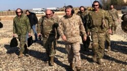 Gen. Frank McKenzie, center front, the top U.S. commander for the Middle East, walks as he visits a military outpost in Syria, Saturday, Jan. 25, 2020.