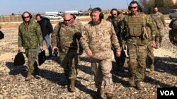 Gen. Frank McKenzie, center front, the top U.S. commander for the Middle East, walks as he visits a military outpost in Syria, Saturday, Jan. 25, 2020.