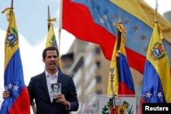 委内瑞拉议会主席、反对派领导人胡安·瓜伊多(Juan Guaido)在反对马杜罗的群众大会上手持宪法。