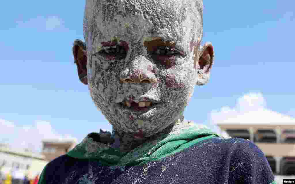 A Somali boy covers his face with sand at the Liido Beach during the last Friday ahead of the Muslim holy month of Ramadan, in Mogadishu, Somalia.