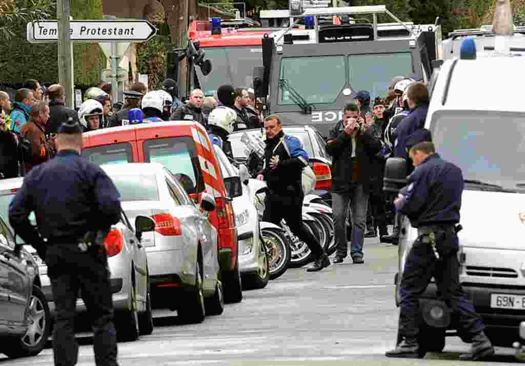 Polisi terlihat di kompleks perumahan Belle Paule saat berupaya menangkap Merah, tersangka pelaku penembakan di Toulouse (AFP).