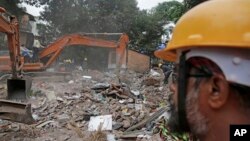 26일 인도 뭄바이의 건물 붕괴 현장에서 구조대가 생존자 수색 작업을 하고 있다.