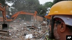 印度孟买一座5层居民楼倒塌后，救援人员连续第二天在瓦砾里寻找幸存者。（2017年7月26日）