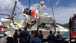 Cảnh sát biển chuẩn bị kéo chiếc thuyền chở di dân bị lật lên bờ tại cảng Vathy trên đảo Samos của Hy Lạp, ngày 5/5/2014.