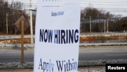 FILE - A sign advertises open jobs at an Embassy Suites hotel in Waltham, Massachusetts, Dec. 13, 2017.