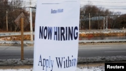 FILE - A sign advertises open jobs at an Embassy Suites hotel in Waltham, Massachusetts, Dec. 13, 2017.