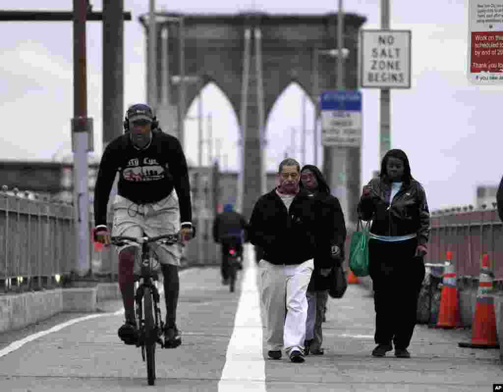 Des New Yorkais se rendant au travail &agrave; pied ou &agrave; v&eacute;lo franchissent le pont de Brooklyn 