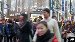 Koreans go about their business in central Seoul, South Korea, December 19, 2010.