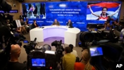 FILE - A Monday, Aug. 8, 2016 photo from files showing the President of the Russian Paralympic Committee Vladimir Lukin, background centre right, during a news conference in Moscow. 