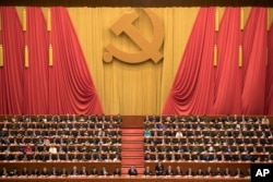 FILE - In this Oct. 18, 2017, file photo, Chinese President Xi Jinping, center, presides over the opening ceremony of the 19th Party Congress held at the Great Hall of the People in Beijing.