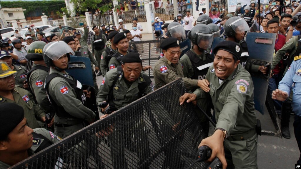 FILE - Police officers set up a roadblock on the outskirts of Phnom Penh, Cambodia, May 30, 2016, ahead of an opposition protest. Having dissolved the country's main opposition party, authorities are now moving against a human rights NGO.