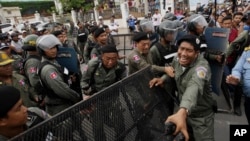 FILE - Police officers set up a roadblock on the outskirts of Phnom Penh, Cambodia, May 30, 2016, ahead of an opposition protest. Having dissolved the country's main opposition party, authorities are now moving against a human rights NGO.