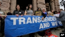 FILE - Members of the transgender community take part in a rally on the steps of the Texas Capitol, March 6, 2017, in Austin, Texas.