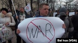 3月7日莫斯科反戰示威。一名示威者手舉標語抗議俄羅斯軍隊進入克里米亞。(美國之音白樺拍攝)