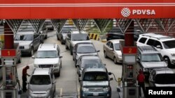 Los automovilistas hacen fila para obtener combustible en una estación de servicio de la petrolera estatal venezolana PDVSA en Caracas, Venezuela, en 2017.