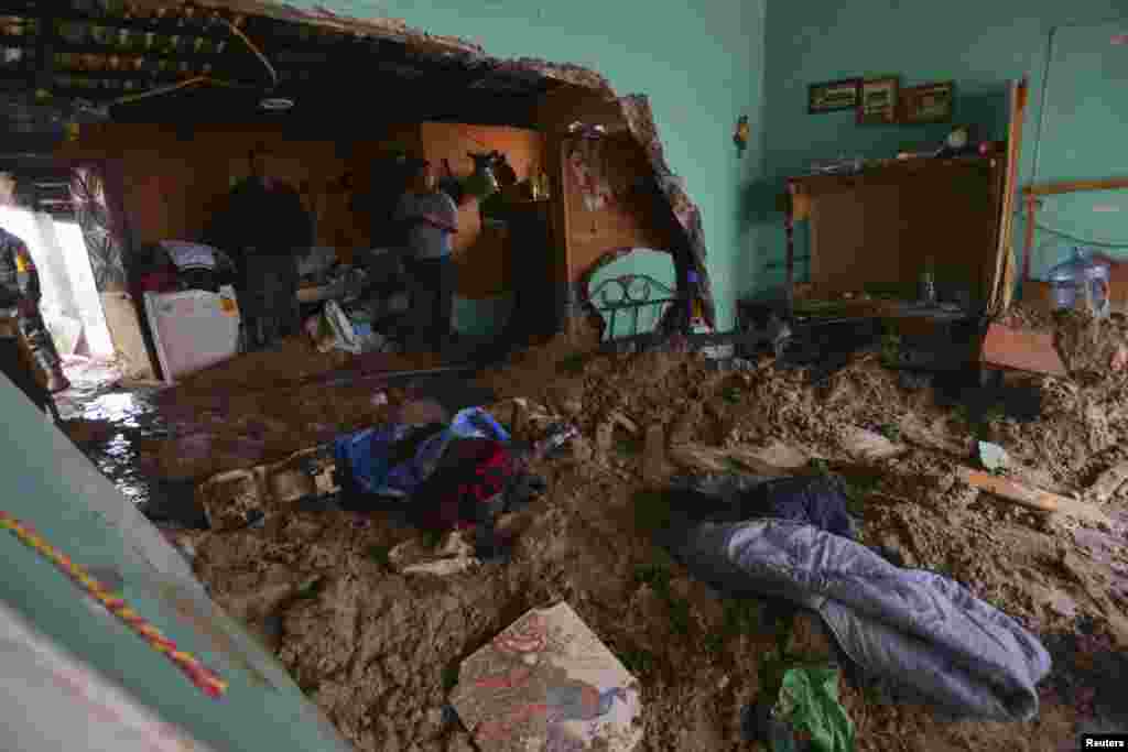 People stand in a house flooded by mud after a mountain landslide in Altotonga in Veracruz state, along Mexico&#39;s Gulf coast, Sept. 16, 2013.&nbsp;