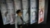 Una mujer camina junto a pancartas de billetes de bolívares venezolanos que se exhiben en el edificio del Banco Central de Venezuela en Caracas, el 23 de mayo de 20217.