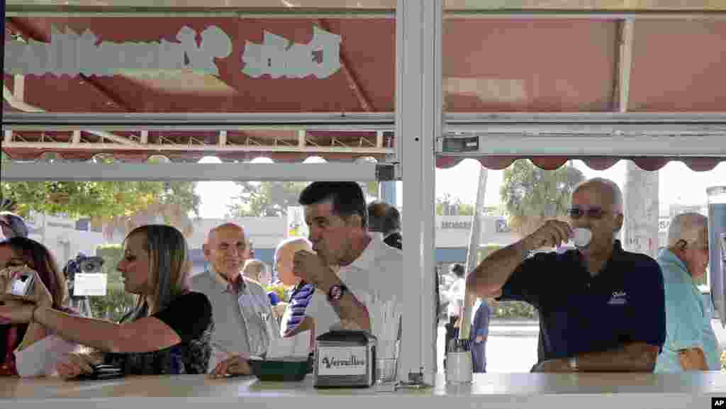 Cuban-American Jose Feliu (right) enjoys a Cuban coffee as he prepares to go to work in the Little Havana area of Miami, Dec. 18, 2014.