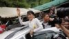 Aung San Suu Kyi waves to people who have gathered to meet her at the Mae La refugee camp, where tens of thousands of her compatriots live, near Mae Sot at the Thai-Burmese border June 2, 2012.