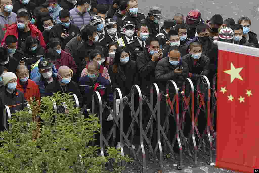 Airport workers wearing face masks wait for COVID-19 testing at the Shanghai Pudong International Airport in Shanghai, China.