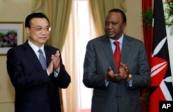FILE - Chinese Premier Li Keqiang, left, and Kenya's President Uhuru Kenyatta applaud after the signing of the Standard Gauge Railway agreement with China at the State House in Nairobi.