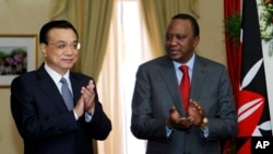 Chinese Premier Li Keqiang, on the left, and Kenyan President Uhuru Kenyatta, applause after signing an agreement with the Gauge Standard with China at the State House of Nairobi, on May 11, 2014.