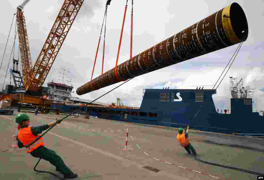 Foundation piles for the wind park &quot;Baltic 2&quot; are loaded onto a transport ship at the EEW Special Pipe Construction GmbH in Rostock, Germany. 
