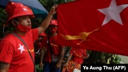 Pendukung partai Liga Nasional untuk Demokrasi (NLD) mengibarkan bendera Myamnar di Yangon pada 8 September 2020. Myanmar melewatkan KTT ASEAN setelah jenderal pemimpin dilarang menghadiri pertemuan itu. (Foto: AFP/Ye Aung Thu)