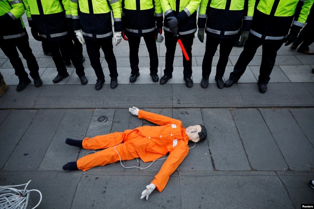 A representation of North Korean leader Kim Jong Un is surrounded by police officers during an anti-North Korea protest in front of the U.S. embassy in Seoul, South Korea.