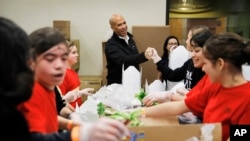 Democratic presidential candidate Sen. Cory Booker, center, D-N.J., tours the Three Square food bank Thursday, Dec. 19, 2019, in Las Vegas. (AP Photo/John Locher)