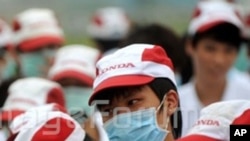 Chinese factory workers wearing masks gather during a strike at an auto parts plant of Honda in Foshan city, south Chinas Guangdong province, 26 May 2010