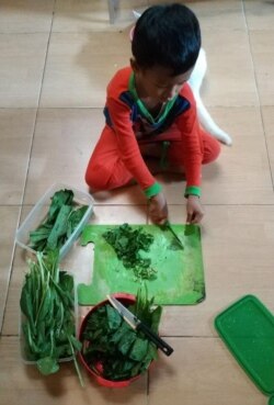 Mikhail (5) di Malang, Jawa Timur, membantu ibunya memasak. (Foto: PHI via Ellen)