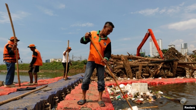 Para petugas membersihkan Sungai Ciliwung di Jakarta yang tercemar oleh sampah plastik dan styrofoam pada 28 Februari 2019. (Foto: Reuters/Willy Kurniawan)